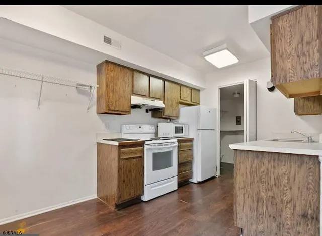 a kitchen with a stove a sink and a refrigerator