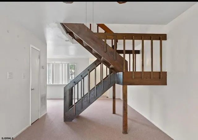 a view of staircase with lots of frames and a window