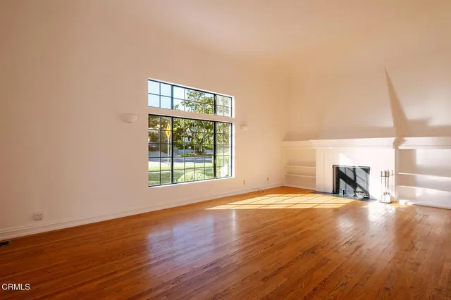a view of a room with wooden floor and windows