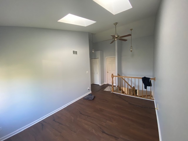 209 North Southport Road Mundelein, IL 60060 - Photo 11 of 18 an empty room with wooden floor and a ceiling fan