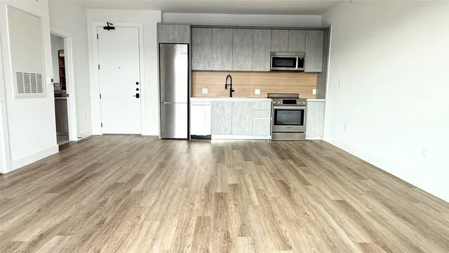 a view of kitchen with wooden floor electronic appliances and window