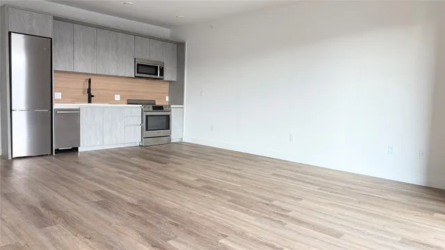 a view of kitchen with wooden floor and electronic appliances