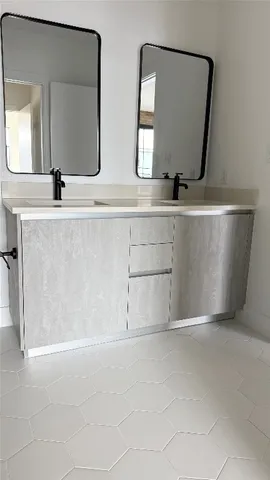 a bathroom with double vanity sink and mirror