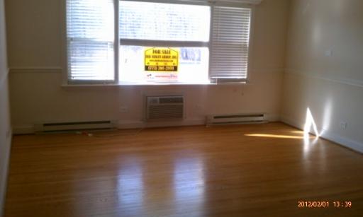 5025 North East River Road, Unit 2B Norridge, IL 60706 - Photo 2 of 9 an empty room with wooden floor and windows