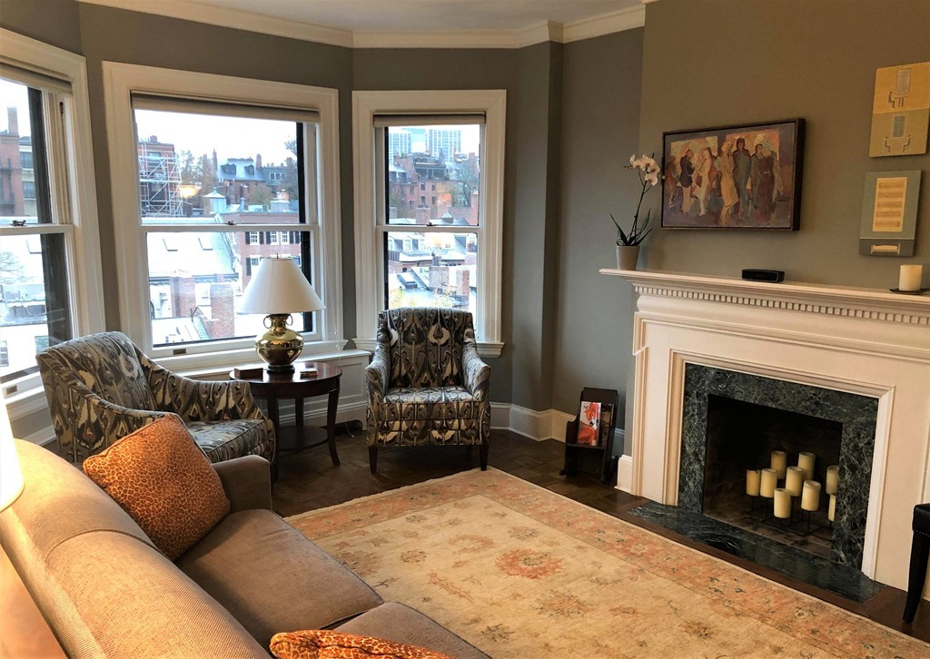 a living room with furniture a large window and a fireplace