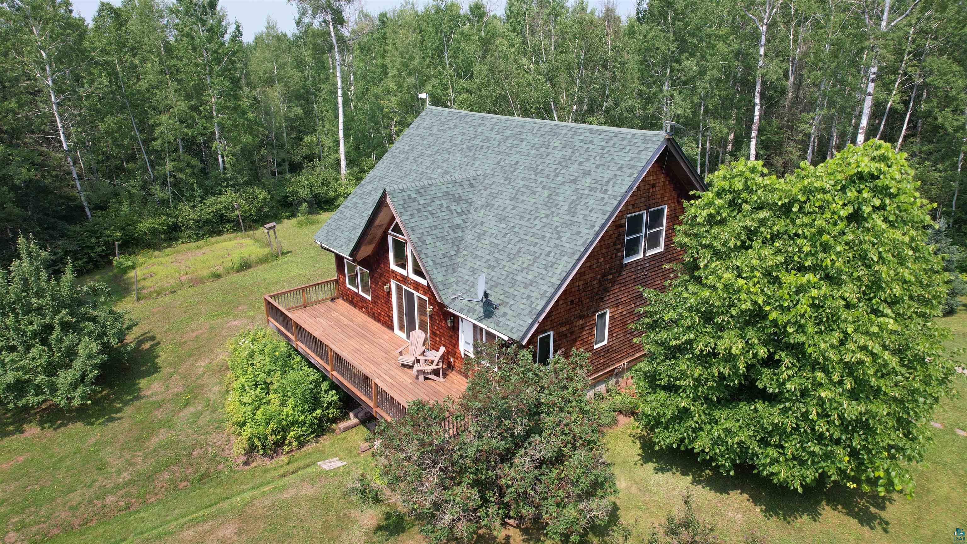 1745 Becks Road Maple, WI 54854 - Photo 50 of 56 Wood-sided home with a green shingle roof, featuring a spacious wood-finish deck