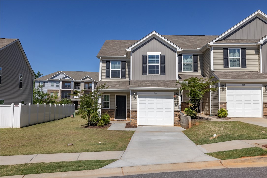 This townhome features a well-maintained exterior, a driveway leading to the garage, and a neatly manicured lawn.