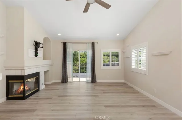 an empty room with windows fireplace and sink