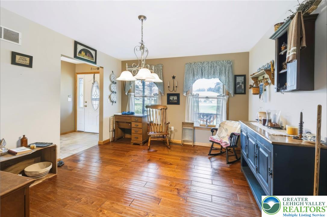 6970 Silver Crest Road Nazareth, PA 18064 - Photo 13 of 35 Rich hardwood flooring extends through this welcoming dining area, illuminated by a classic chandelier.