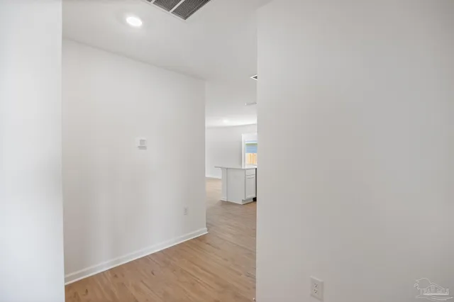 a view of a hallway with wooden floor and closet