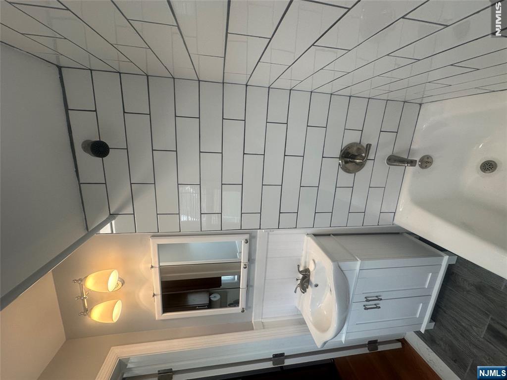159 Division Avenue, Unit 2 Garfield, NJ 07026 - Photo 14 of 14 a bathroom with a sink a toilet a mirror and shower