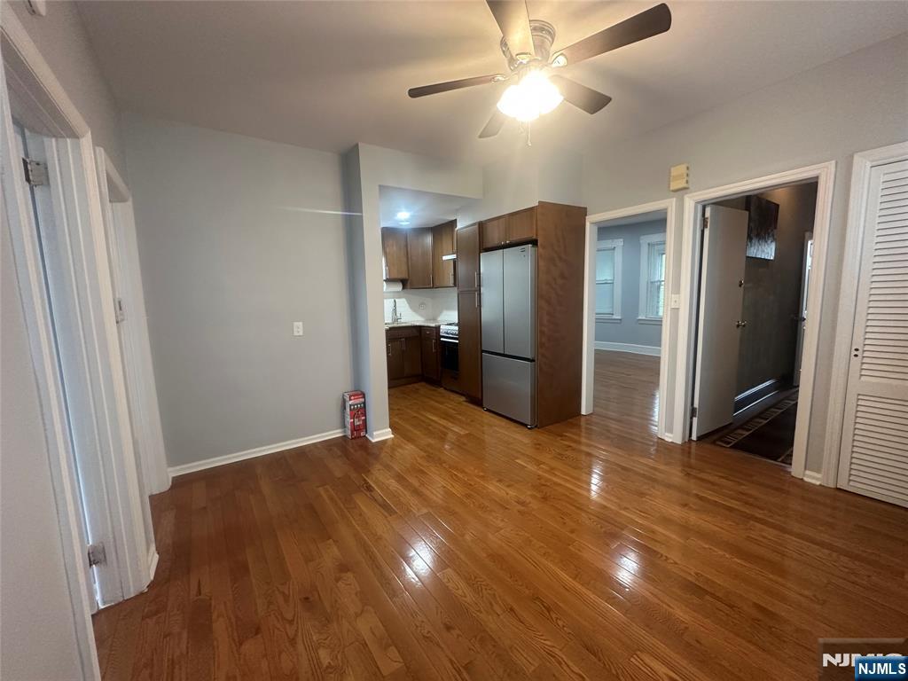 159 Division Avenue, Unit 2 Garfield, NJ 07026 - Photo 5 of 14 a view of an empty room with wooden floor and a ceiling fan