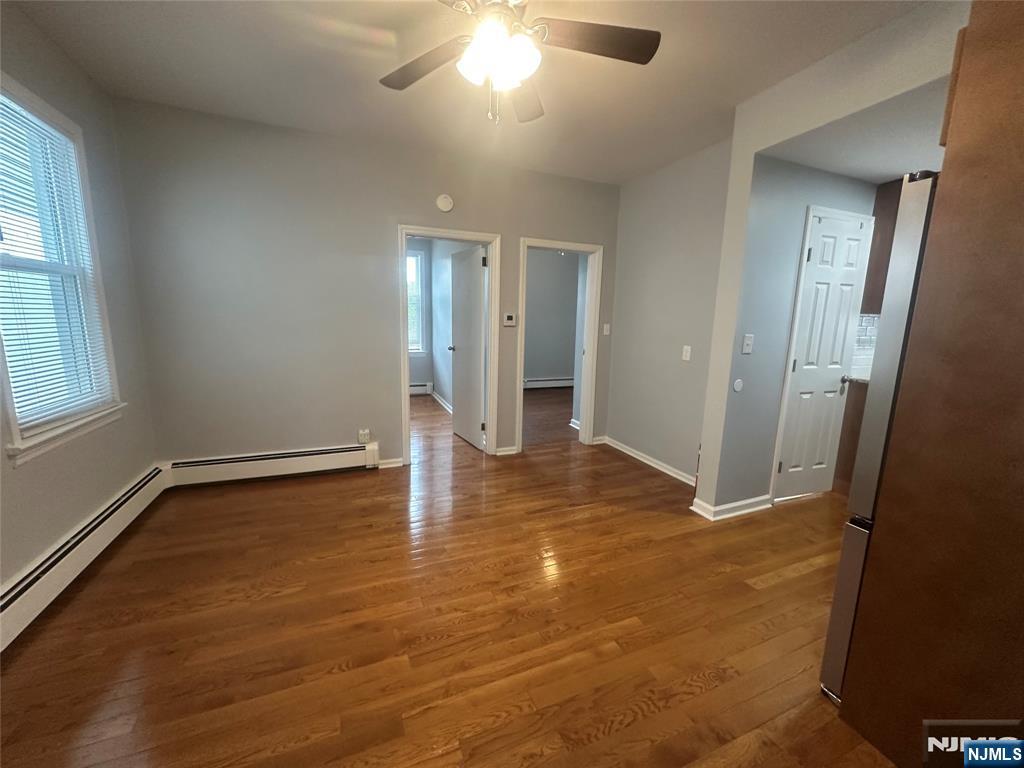 159 Division Avenue, Unit 2 Garfield, NJ 07026 - Photo 6 of 14 an empty room with wooden floor and windows