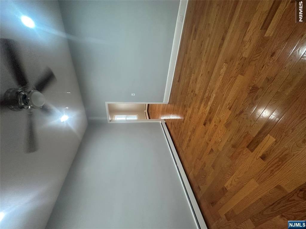 159 Division Avenue, Unit 2 Garfield, NJ 07026 - Photo 7 of 14 an empty room with wooden floor and windows