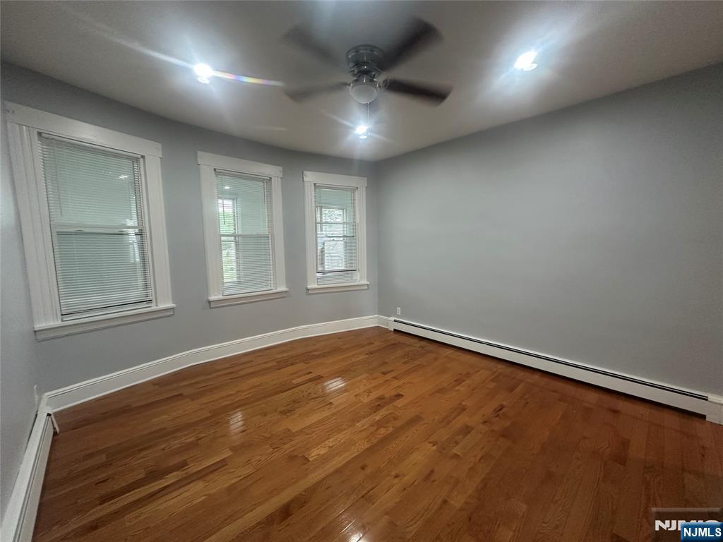 159 Division Avenue, Unit 2 Garfield, NJ 07026 - Photo 8 of 14 an empty room with wooden floor and windows