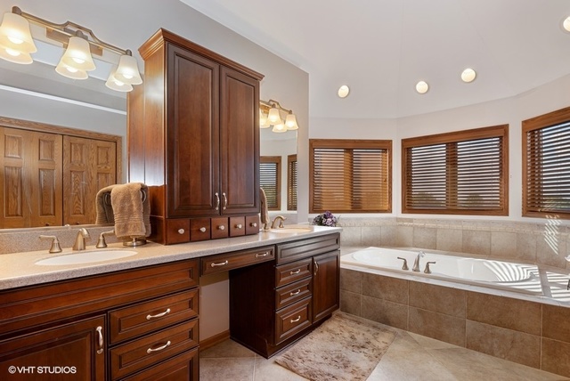 3812 Redwood Court Spring Grove, IL 60071 - Photo 21 of 37 a bathroom with double vanity sinks a large mirror and a bathtub