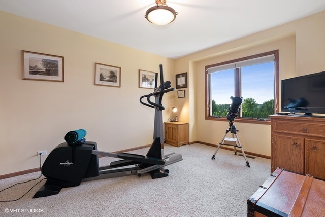 3812 Redwood Court Spring Grove, IL 60071 - Photo 25 of 37 a living room with furniture gym equipment and a flat screen tv