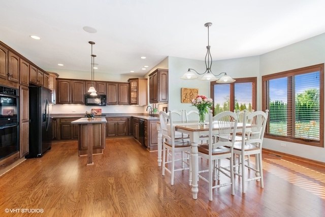 3812 Redwood Court Spring Grove, IL 60071 - Photo 4 of 37 a view of a dining room and livingroom with furniture wooden floor a chandelier