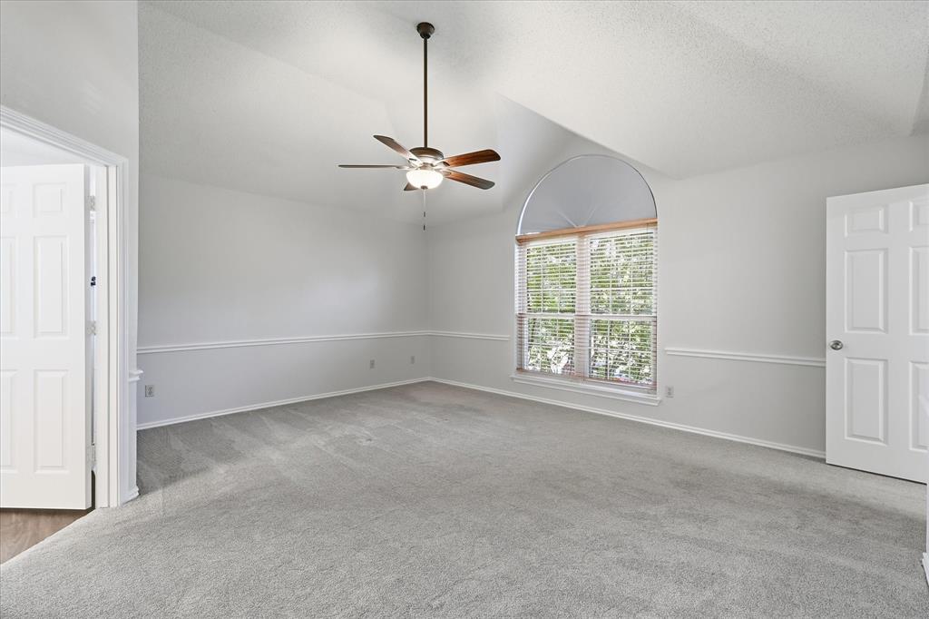 318 Lodge Road Coppell, TX 75019 - Photo 21 of 35 The oversized primary suite features a vaulted ceiling, large arched window and an abundance of space for a relaxing sitting area.
