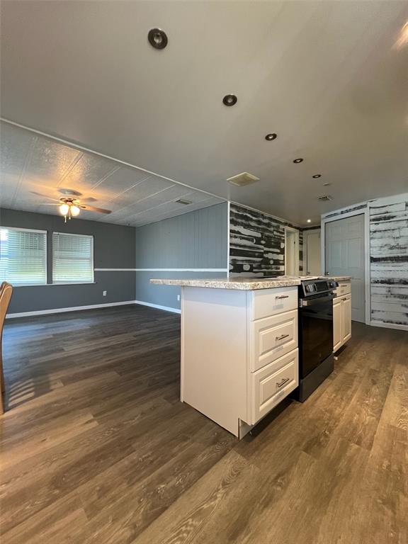 6528 Roosevelt Drive Port Richey, FL 34668 - Photo 12 of 42 a kitchen with stainless steel appliances a stove and more cabinets