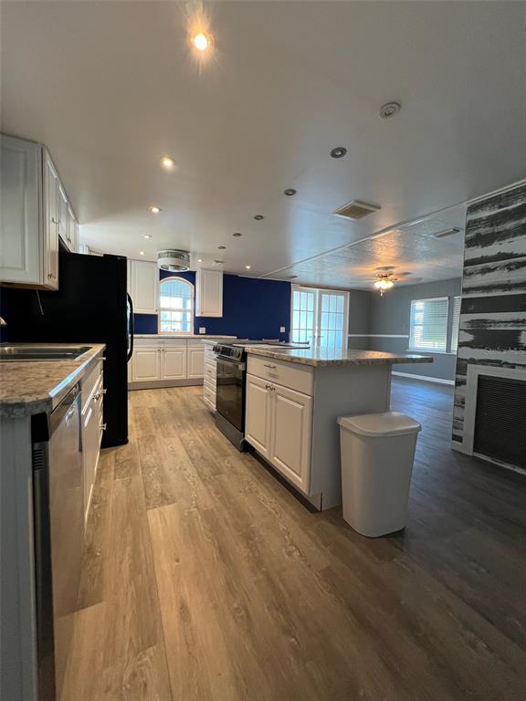 6528 Roosevelt Drive Port Richey, FL 34668 - Photo 14 of 42 a kitchen with stainless steel appliances a sink a stove top oven a counter space and cabinets