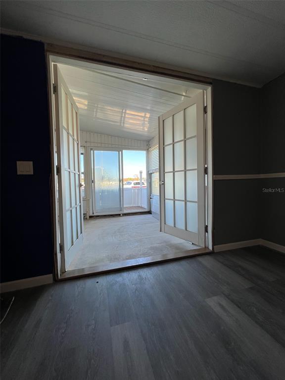 6528 Roosevelt Drive Port Richey, FL 34668 - Photo 28 of 42 an empty room with wooden floor and windows