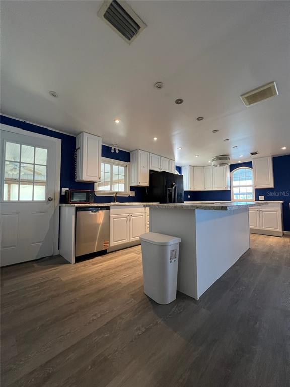 6528 Roosevelt Drive Port Richey, FL 34668 - Photo 10 of 42 a kitchen with stainless steel appliances kitchen island wooden cabinets and a fireplace