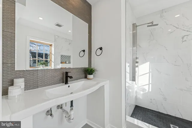 a bathroom with a tub sink and mirror