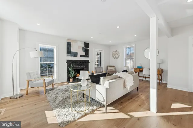 a living room with furniture a large window and a fireplace