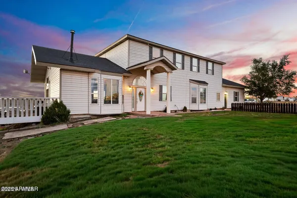 a view of a white house with a big yard