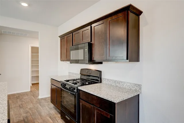 a kitchen with a sink cabinets and wooden floor