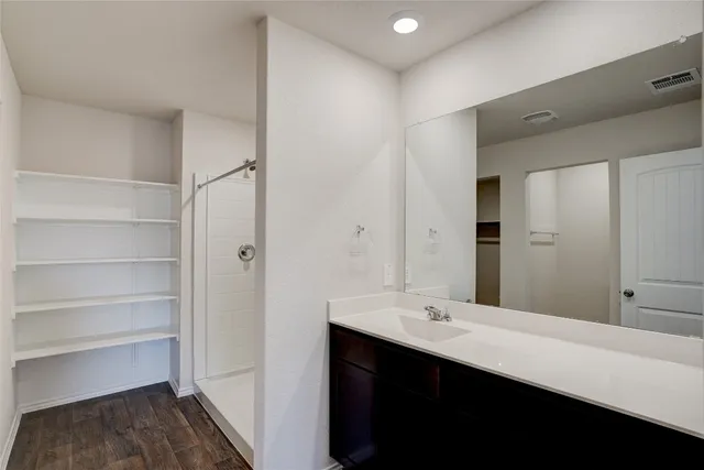 a bathroom with a double vanity sink a mirror and a bathtub