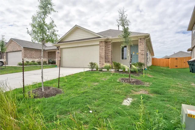 a view of a house with backyard and a garden