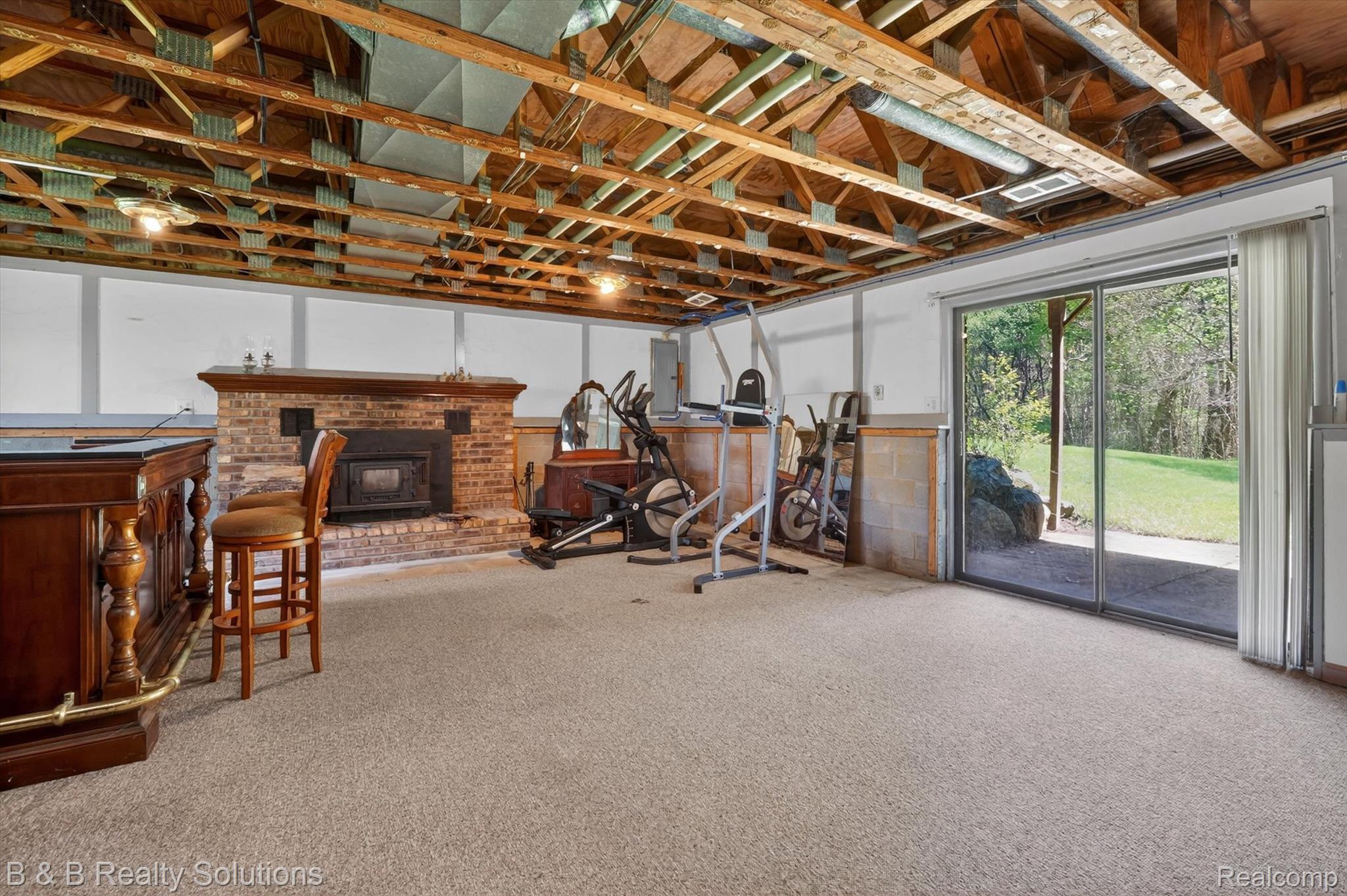 2467 North Lake George Road Metamora, MI 48455 - Photo 29 of 46 Workout area with a brick fireplace, carpet, and electric panel