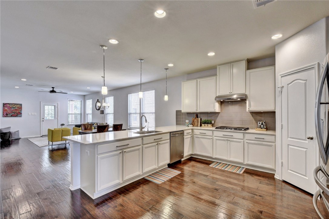 309 Square Bend Georgetown, TX 78633 - Photo 1 of 1 a kitchen with stainless steel appliances granite countertop a stove top oven a sink dishwasher a refrigerator and cabinets with wooden floor