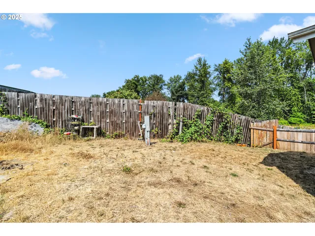a view of wooden house with a yard