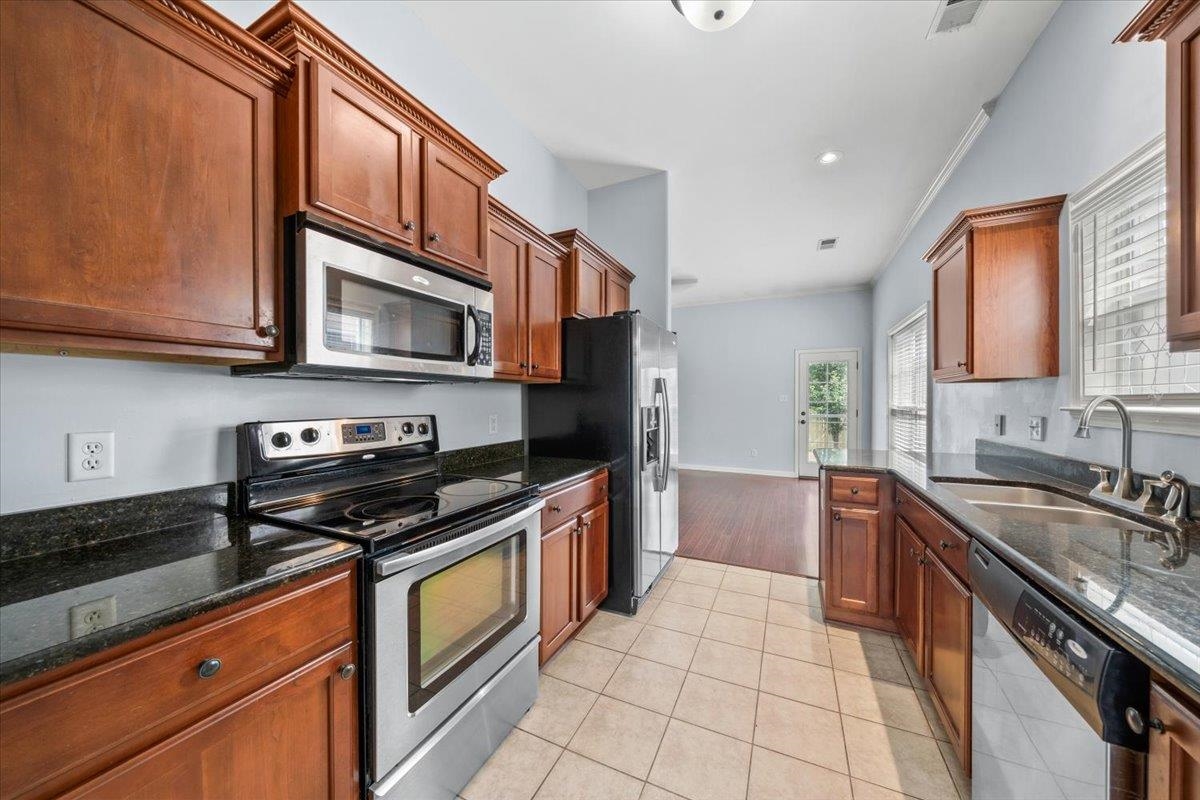 6972 Wynne Ridge Road North Cordova, TN 38016 - Photo 8 of 23 Kitchen featuring appliances with stainless steel finishes, a sink, dark stone countertops, light tile patterned flooring, and recessed lighting