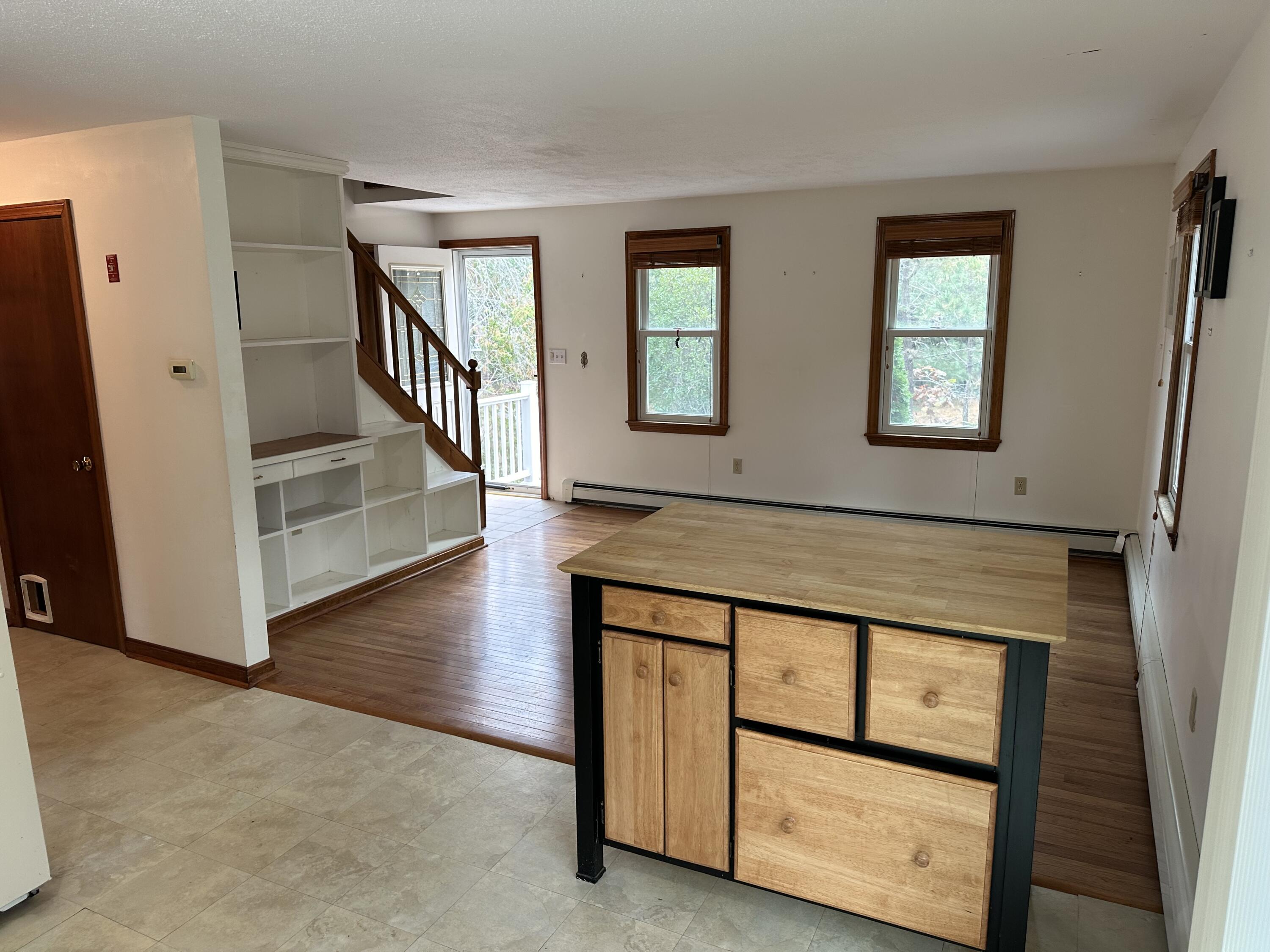 16 Warren Road Wellfleet, MA 02667 - Photo 14 of 24 a view of an entryway with wooden floor leading to a furnished livingroom and windows