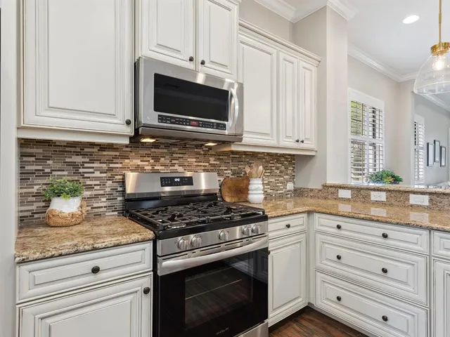 a kitchen with granite countertop cabinets stainless steel appliances and a sink