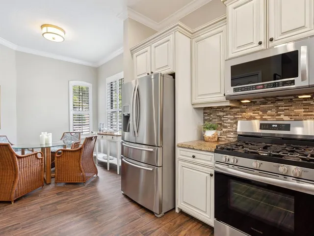 a kitchen with stainless steel appliances a stove refrigerator and microwave