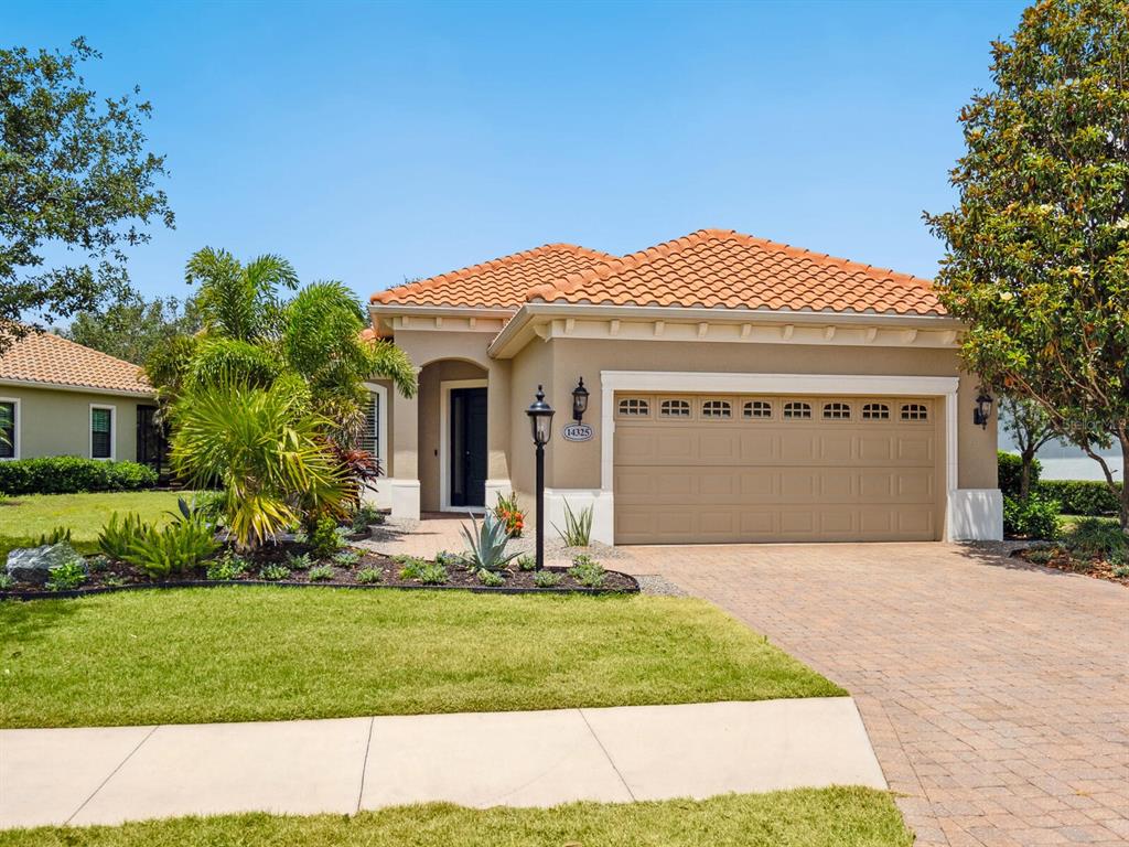 14325 Stirling Drive Lakewood Ranch, FL 34202 - Photo 2 of 53 a front view of a house with a yard and garage