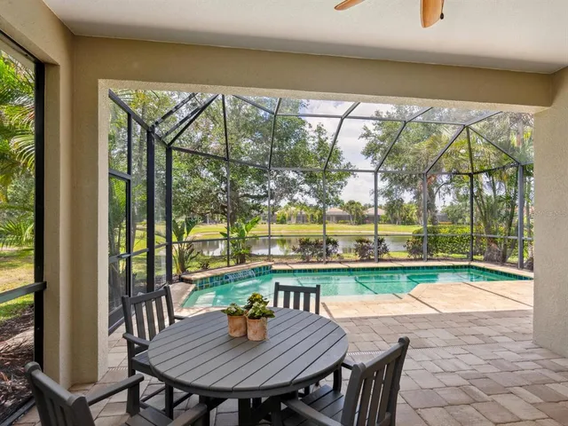 a view of a patio with a table chairs and a backyard