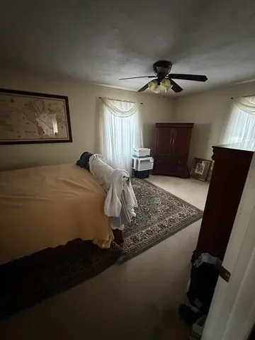 a bedroom with bed cabinet and window