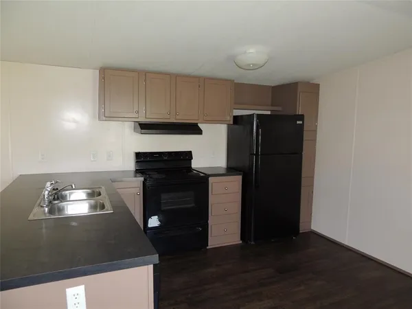 a kitchen with a refrigerator and a stove top oven