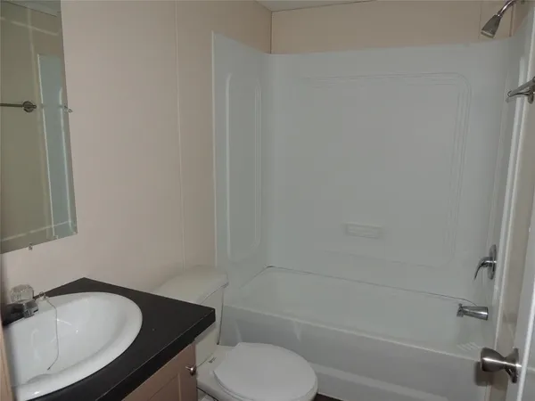 a bathroom with a granite countertop toilet sink and bathtub