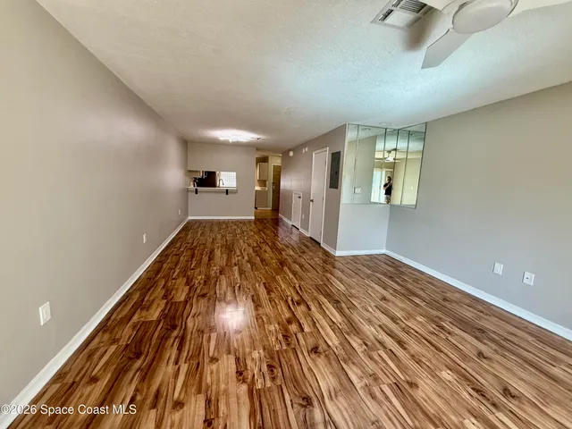a view of a livingroom with wooden floor and a ceiling fan