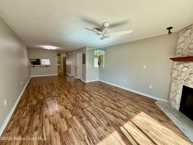 a view of a room with wooden floor and floor to ceiling window