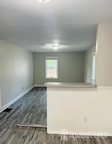 a view of an empty room and wooden floor