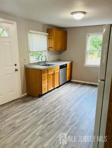an empty room with wooden floor and window