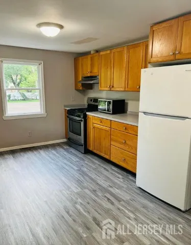 a kitchen with wooden floors and white appliances